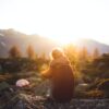 person sitting on rock at golden hour